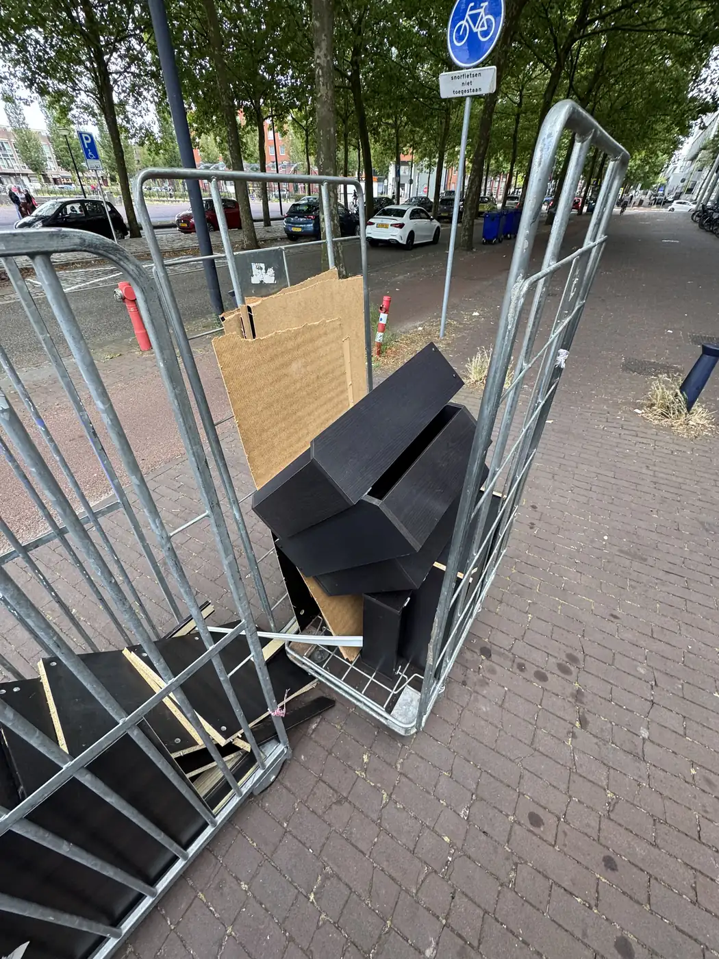 Rolcontainer met de losse panelen van een gedemonteerde kledingkast